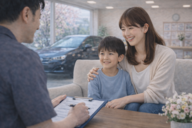 明るいショールームで母親と子どもが安心した表情でスタッフと車の購入や売却について前向きに相談している商談風景