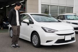 販売店に停まる白いハイブリッド車