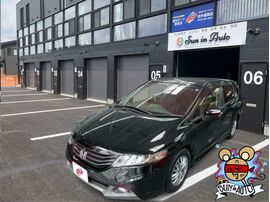 カーマッチ盛岡店の店舗前に停車した黒のホンダ・オデッセイ。左側には「予想を超える感動をあなたとカーマッチ！！」と書かれた白い幟旗（のぼり）が立っている。