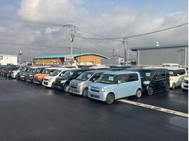 梅雨空の下、カーマッチの展示場に並ぶ燃費の良い中古軽自動車の在庫