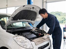 車のボンネットを開ける男性