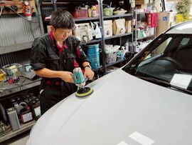 MiXのスタッフが車のボディを丁寧に磨き、コーティングで新車のような輝きを出している様子