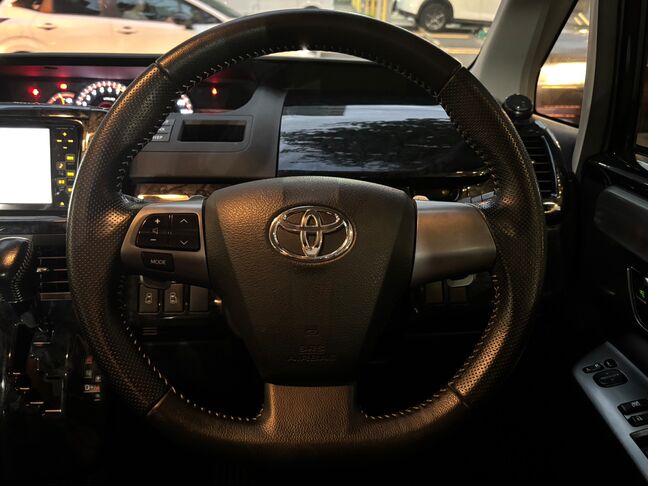 手に馴染む革巻きステアリング。運転席周りの状態も良好です。【ヴォクシー】